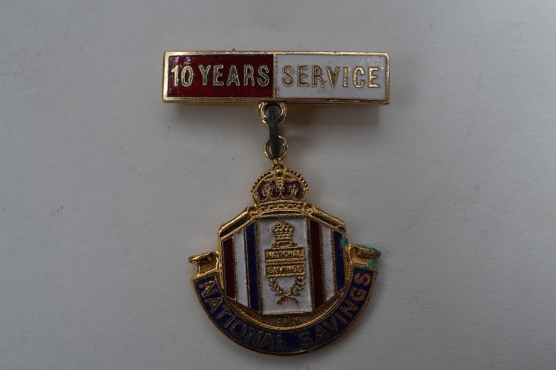 A collection of primarily 20th century military badges, lapel badges, shoulder titles, and other related ephemera, including seventeen military cap badges, cloth badges, ARP badges, etc., together with a military tin box